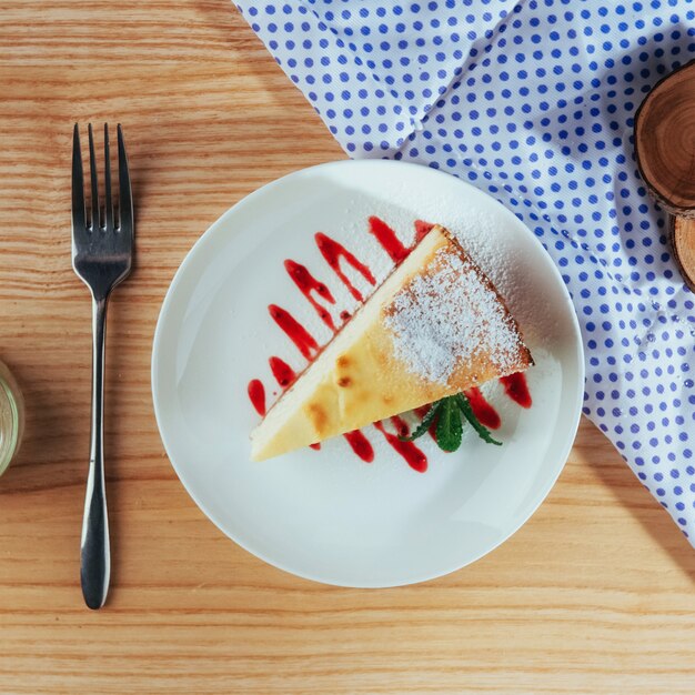 カフェの三角形のチーズケーキ。木製のテーブルの上