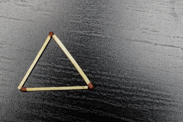 Photo the triangle is made of matches on a black background