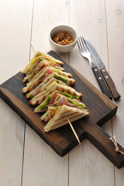 Triangle sandwiches with ham strung on wooden skewers 