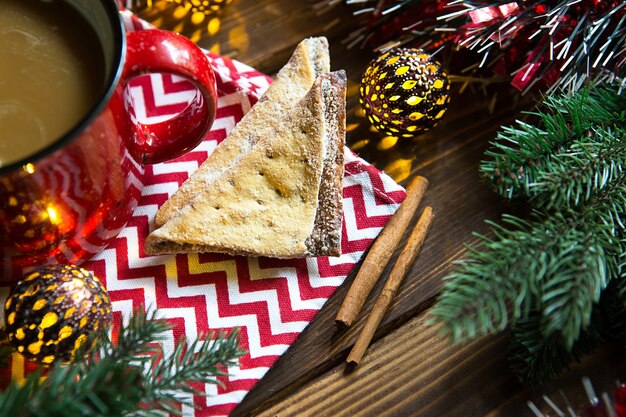 Triangular cookies with powdered sugar and cinnamon on a napkin with a zigzag pattern