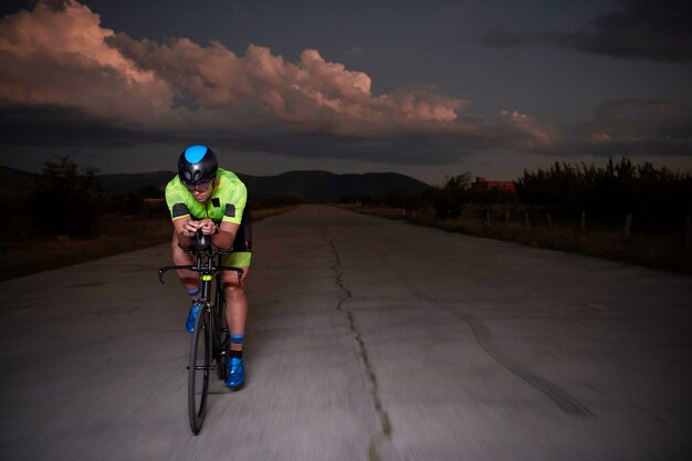 トライアスロン選手が夜に高速で自転車に乗っている