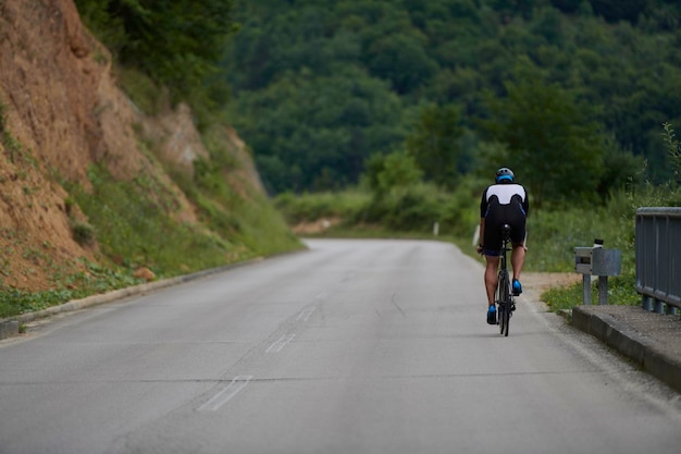 トライアスロン選手が黒い服を着て自転車に乗っている