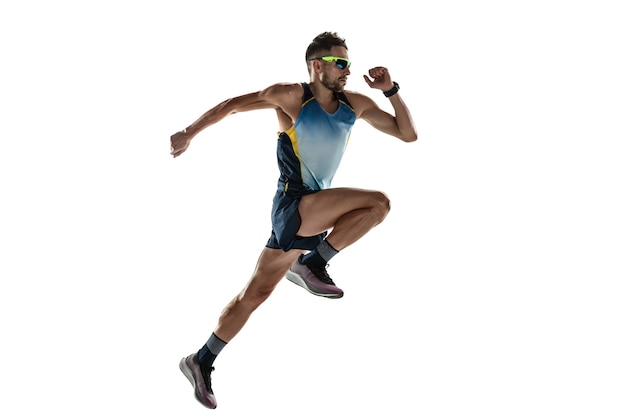 Triathlon male athlete running isolated on white studio background. Caucasian fit jogger, triathlete training wearing sports equipment. Concept of healthy lifestyle, sport, action, motion. In jump.