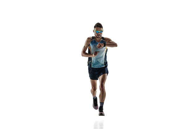 Triathlon male athlete running isolated on white studio background. Caucasian fit jogger, triathlete training wearing sports equipment. Concept of healthy lifestyle, sport, action, motion. Time check.