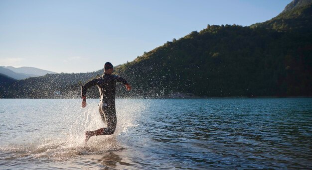 Foto triatlon atleet begint met zwemtraining op het meer