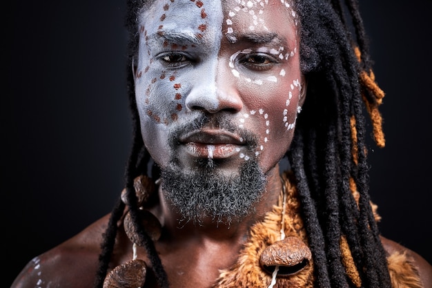 Tribal guy with ethnic authentic make-up looks at front