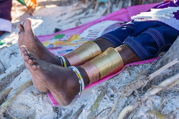 Masai tribale gamba con un braccialetto colorato, primo piano. zanzibar, tanzania, africa orientale