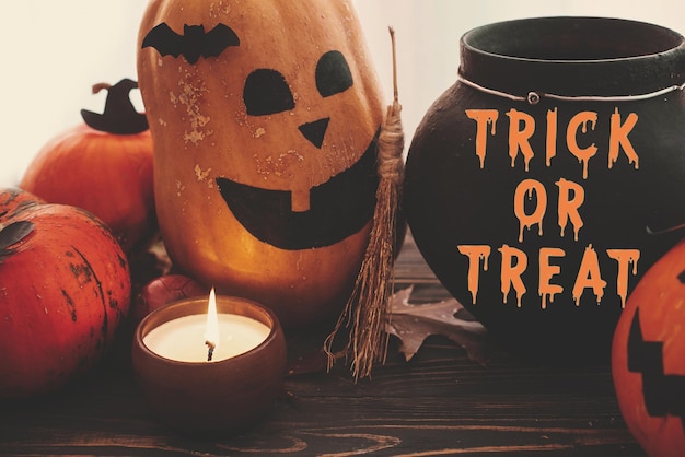 Photo trick or treat bloody text happy halloween pumpkins jackolantern witch cauldron bats spider candle autumn leaves on black wood in light halloween decoration season's greeting