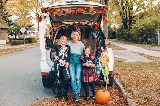 Photo trick or trunk family celebrating halloween in trunk of car mother with kids