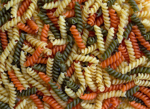 Tricolor, dry and raw pasta, food for background