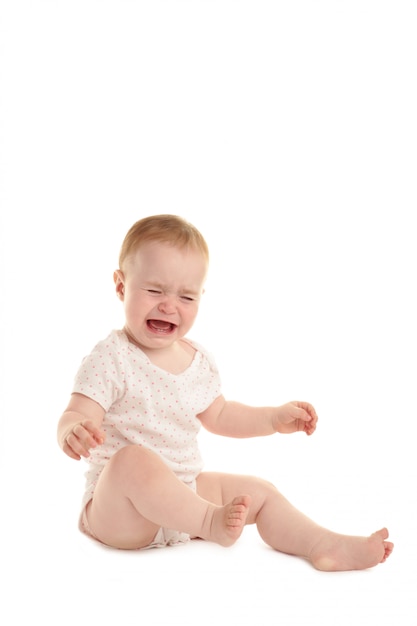 Triest babymeisje zitten en huilen geïsoleerd op een witte achtergrond