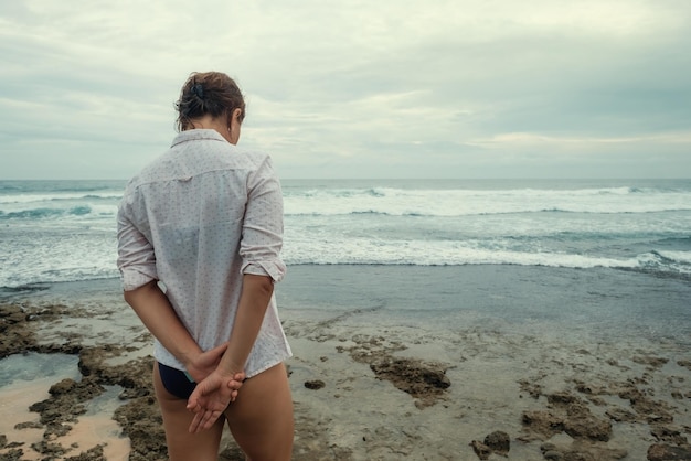 Triest blanke vrouw staan op het strand Achteraanzicht