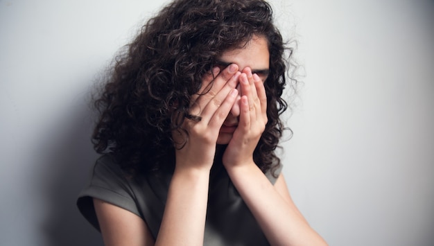 Triest depressieve vrouw hand dicht gezicht.