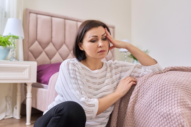 Triest gefrustreerde depressieve volwassen vrouw die thuis op de grond zit