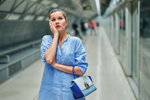 Triest jonge vrouw met handtas in metrostation