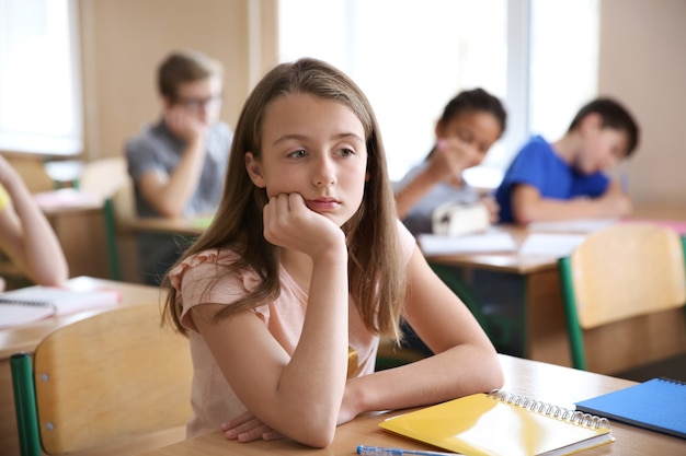 Triest meisje zit in de klas.