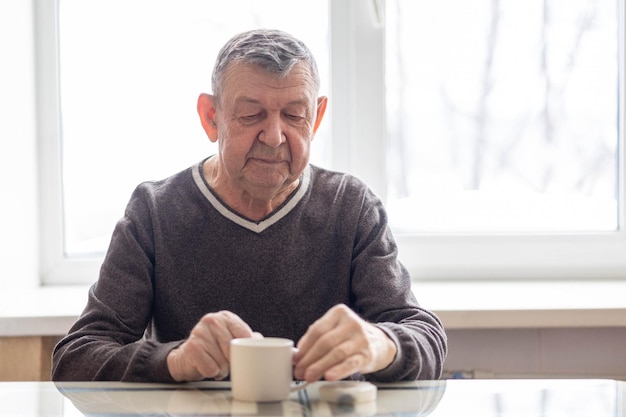 Triest portret van oudere man waar de senior aan zit