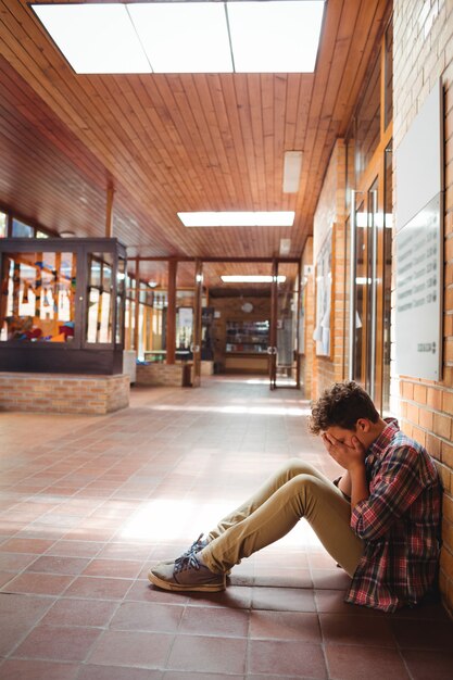 Triest schooljongen zit alleen in gang