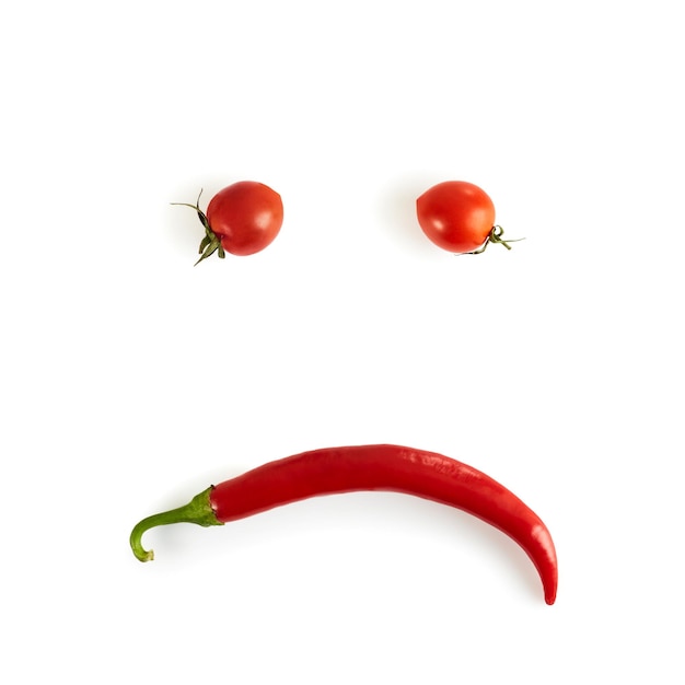 Triest smiley cherry tomaten en chili peper Uitzicht van bovenaf Witte achtergrond