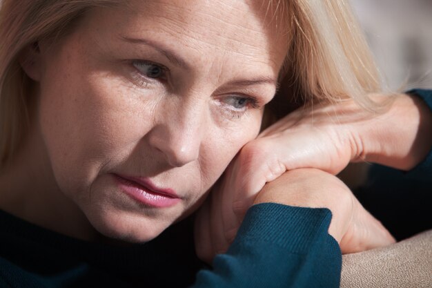 Foto triest vrouw zittend op een bank in de woonkamer