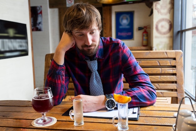 Trieste jonge man zit alleen in een bar ongezonde levensstijl alcoholverslaving