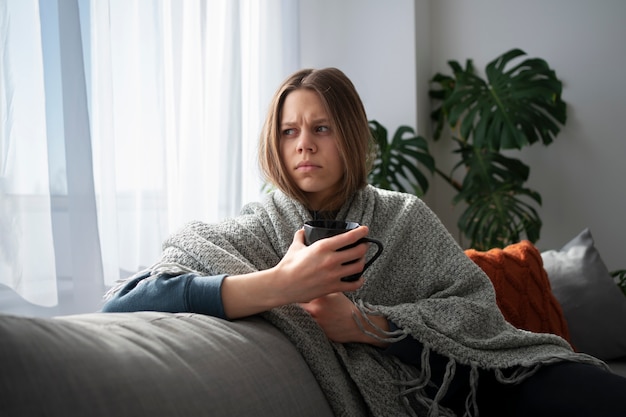 Foto trieste jonge vrouw thuis