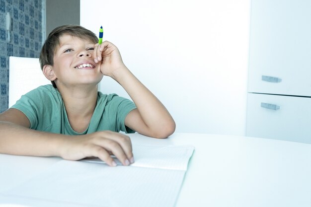 Trieste jongen met boek doet school huiswerk. Terug naar school. Ongelukkige schooljongen met schoolboeken. Afstand leren.