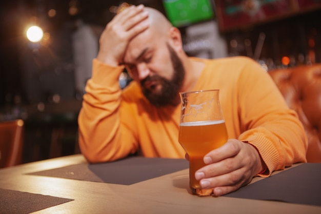 Trieste man alleen drinken in de bier pub.