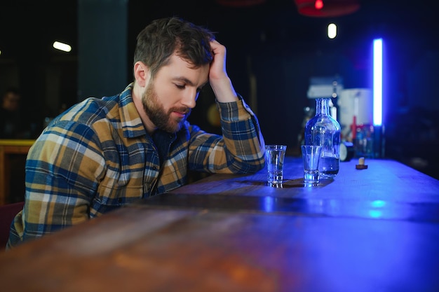 Trieste man zit aan de bar tegen alcoholverslaving