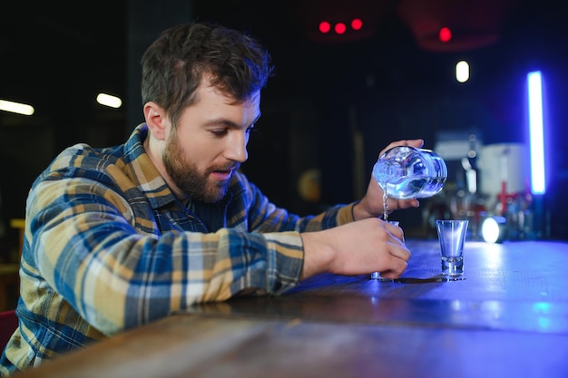 Trieste man zit aan de bar tegen alcoholverslaving