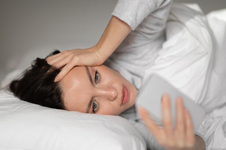 Trieste ongelukkige jonge europese vrouw ligt op wit bed wordt wakker en leest bericht op smartphone in slaapkamer