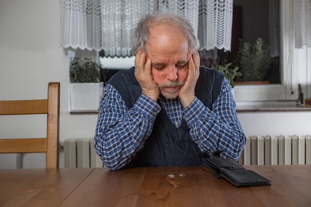 Foto trieste senior man met een lege portemonnee economische crisis tijdens pandemie covid coronavirus