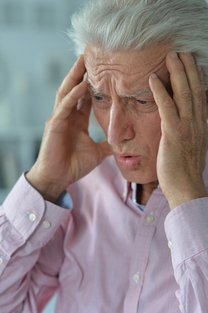 Foto trieste zieke senior man met hoofdpijn