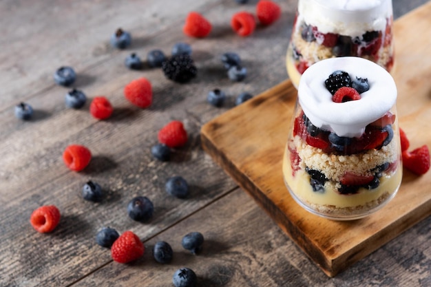 Trifle dessert with berries and cream on wooden tabletypical english dessert