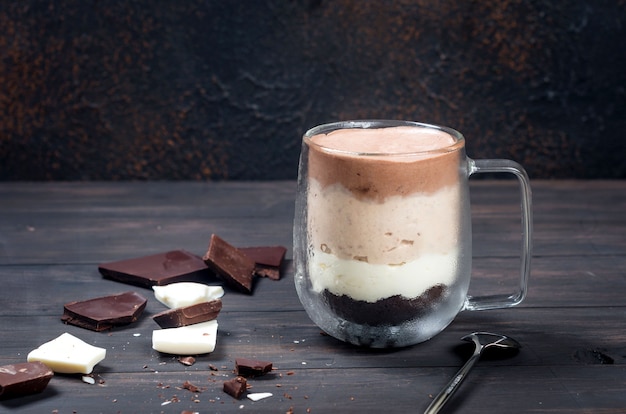 Trifles mousse Three Chocolates in glass on dark wooden background