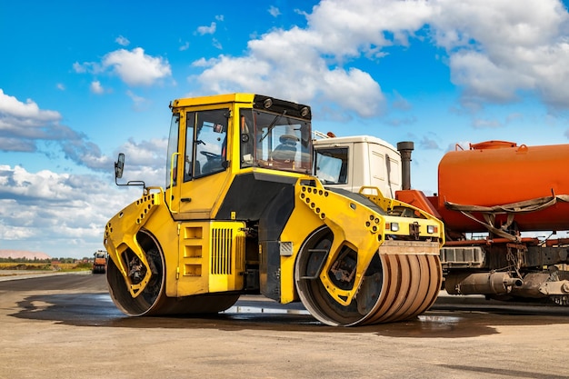 Trillende wals legt asfalt op een nieuwe weg in aanbouw Close-up van het werk van wegmachines Bouwwerkzaamheden aan de aanleg van stedelijke snelwegen