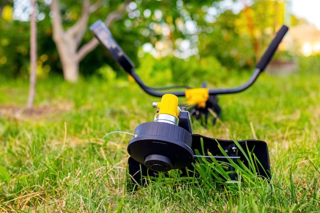 Trimmer for mowing the grass in the garden among the thick\
grass