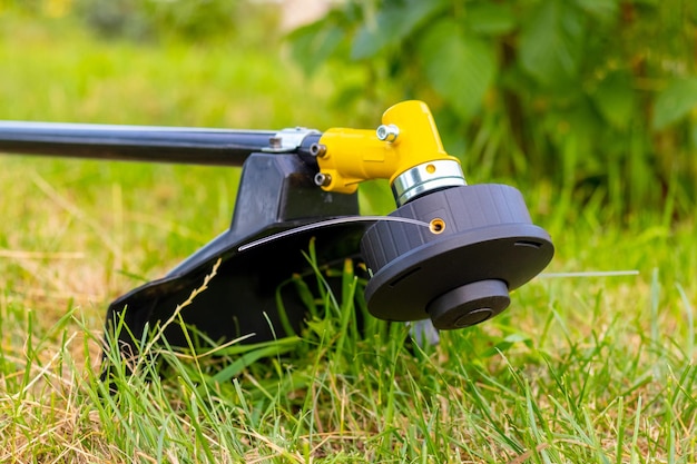 Trimmer for mowing the grass in the garden among the thick grass