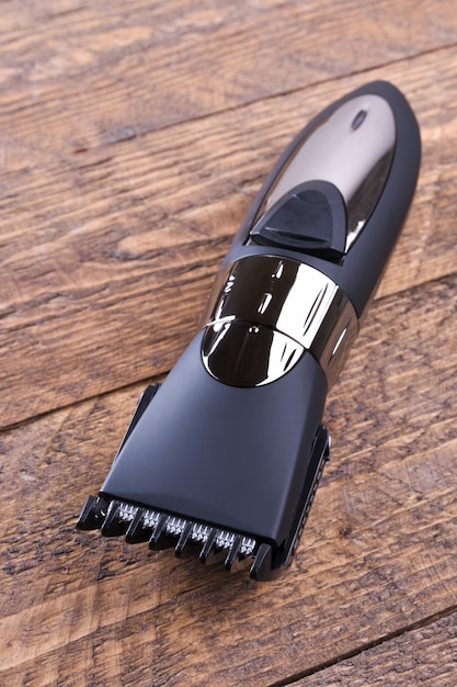 Trimmer with nozzles. Buying a new wireless trimmer. On a wooden table. Close-up.