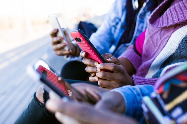 Trio vrienden die mobiele telefoon in de straat gebruiken.