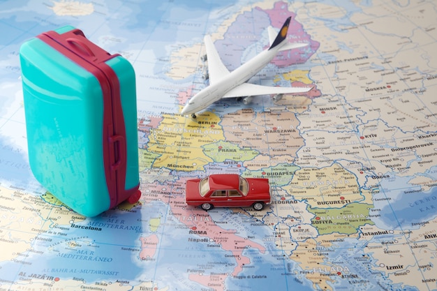 Trip or traveling by airplane concept. Miniature toy airplane and suitcases on map.