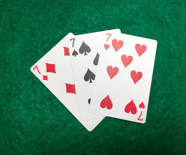 그린 베이즈 포커 게임 컨셉의 클럽 세븐 또는 다이아몬드 세븐의 탁자 위의 트리플 세븐