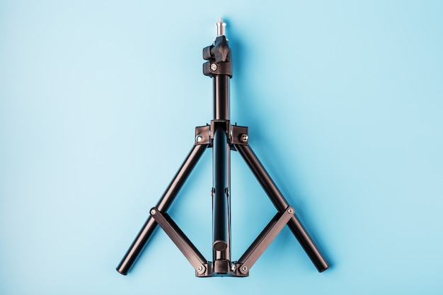 Tripod on a blue background for a photo-video camera and flash on a blue background.