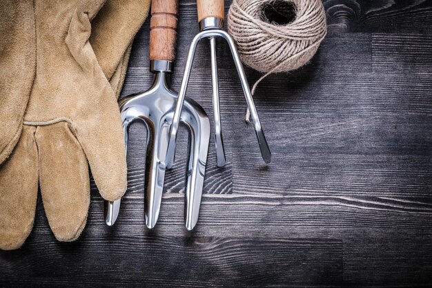 Troffelvork hark lederen handschoenen streng van touw tuinieren concept.