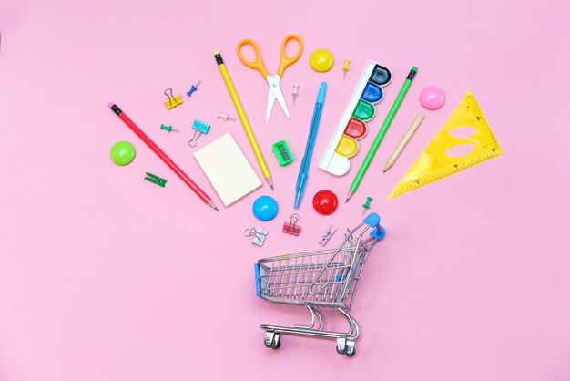 Trolley banner with school supplies on pink background. Back to school concept. Buying stationery for a first grader