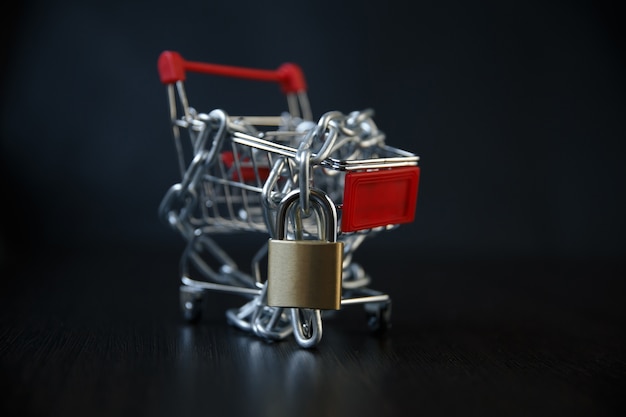 A trolley on computer keyboard with padlocks / Security of online shopping concept