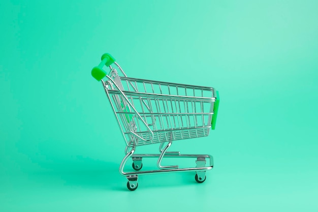 Trolley from the supermarket minimal on a colored background. Sales and purchases concept.