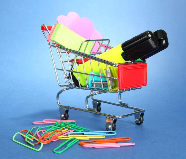 Trolley met schoolspullen op blauwe achtergrond