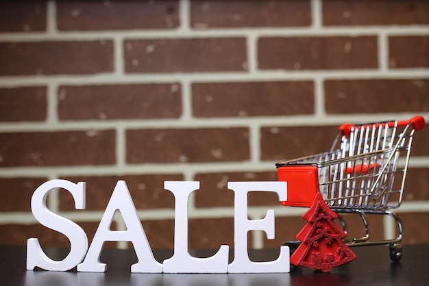 Trolley for products on a brick wall background New Year's sale of shares