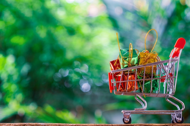 Trolley voor supermarkt of winkelwagentje en geschenkdozen met groene natuur achtergrond